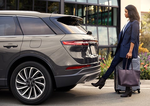 A woman with her hands full uses her foot to activate the available hands-free liftgate. | Carman Lincoln in New Castle DE