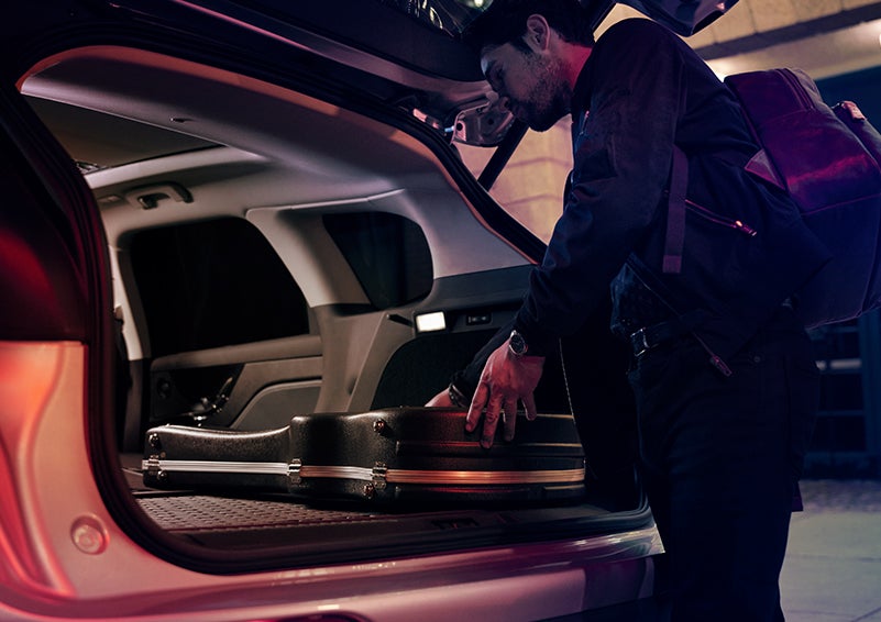A man is shown loading cargo into the rear of a 2024 Lincoln Corsair® SUV with the second-row seats folded flat. | Carman Lincoln in New Castle DE