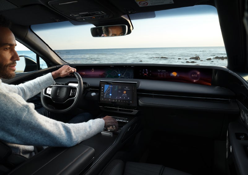 A driver of a parked 2024 Lincoln Nautilus® SUV takes a relaxing moment at a seaside overlook while inside his Nautilus. | Carman Lincoln in New Castle DE