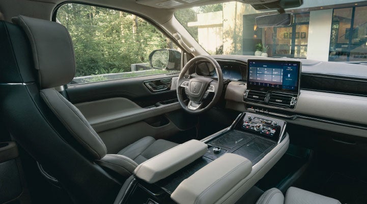 The front cabin inside a 2024 Lincoln Navigator® SUV features available leather seating surfaces for a comfortable drive.