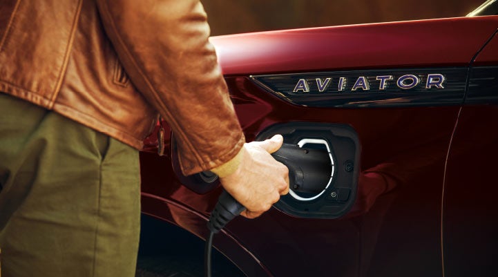 A hand is shown plugging in the charger into the charging port of a 2021 Lincoln Aviator | Carman Lincoln in New Castle DE