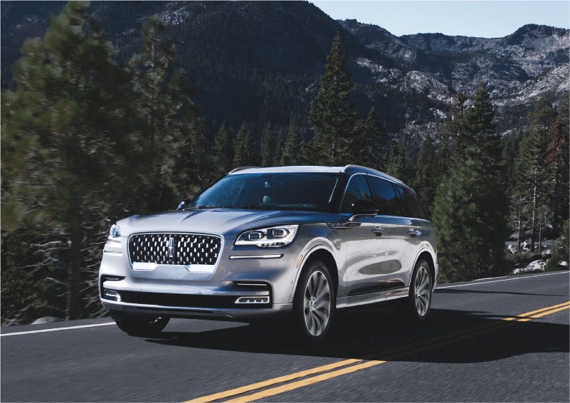 A 2023 Lincoln Aviator® Grand Touring SUV being driven on a winding road to demonstrate the capabilities of all-wheel drive | Carman Lincoln in New Castle DE