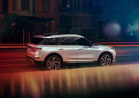 A 2023 Lincoln Corsair® SUV is shown parked in the city at night. | Carman Lincoln in New Castle DE