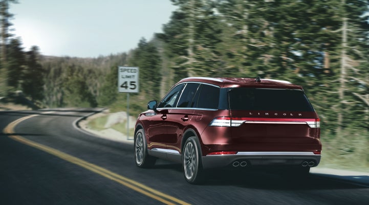 A 2024 Lincoln Aviator® SUV is being driven on a winding mountain road | Carman Lincoln in New Castle DE