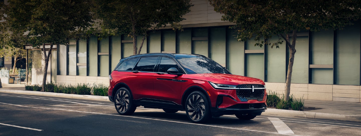 A 2025 Lincoln Nautilus® SUV with an available hybrid powertrain is parked in an urban setting. | Carman Lincoln in New Castle DE
