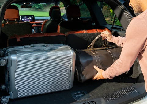 A man loads luggage into the rear of a 2026 Lincoln Aviator® SUV through the opened rear liftgate. | Carman Lincoln in New Castle DE