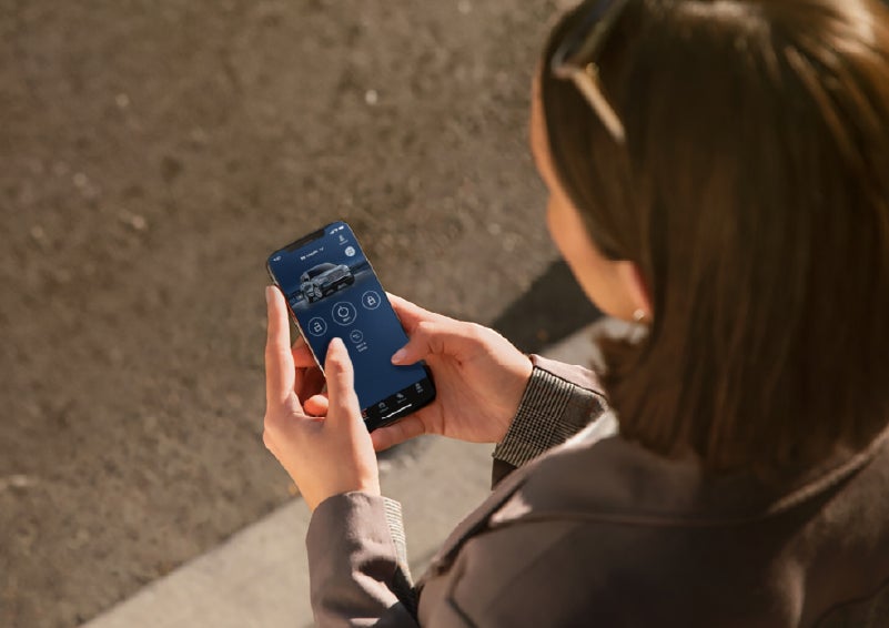 A person is shown interacting with a smartphone to connect to a Lincoln vehicle via the Lincoln Way® app. | Carman Lincoln in New Castle DE