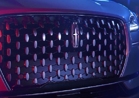 The grille of a 2025 Lincoln Corsair&reg; SUV reflects neon light at night. | Carman Lincoln in New Castle DE