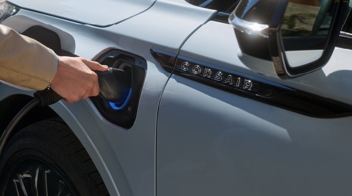 A hand is plugging in a 2026 Lincoln Corsair® Grand Touring Plug-in Hybrid SUV. | Carman Lincoln in New Castle DE