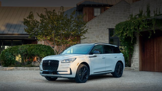 A 2026 Lincoln Corsair® SUV is parked in front off a luxury home. | Carman Lincoln in New Castle DE