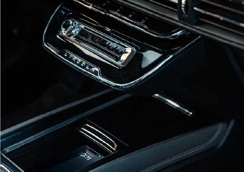 A smartphone rests on the available wireless charging pad in the front center console cubby. | Carman Lincoln in New Castle DE