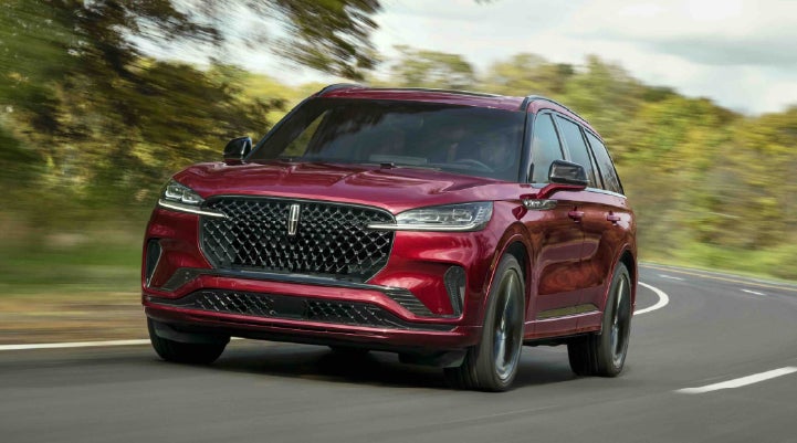 A 2027 Lincoln Aviator® SUV is being driven on a country road | Carman Lincoln in New Castle DE